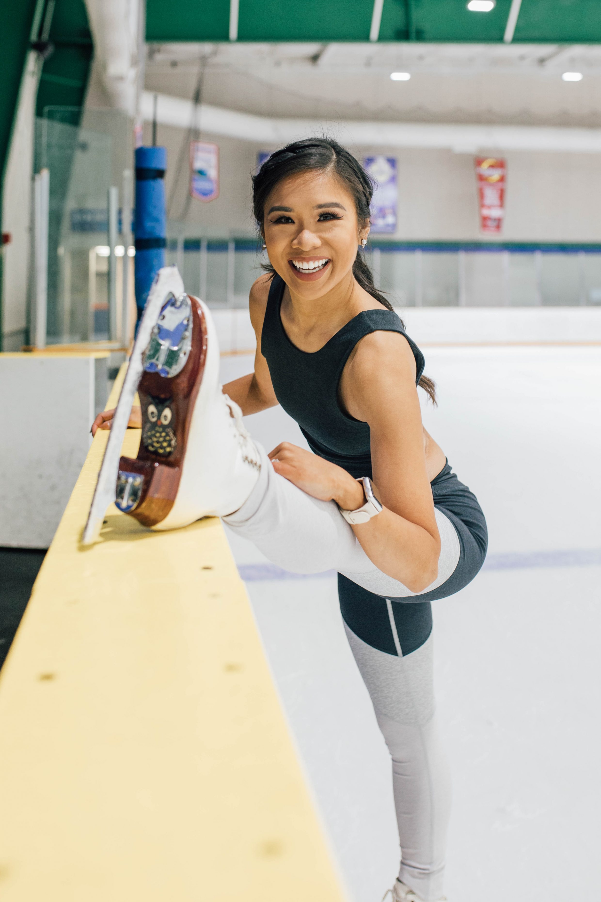 Hoang-Kim stretches by the board at Chilled Ponds Ice RInk in Outdoor Voices apparel