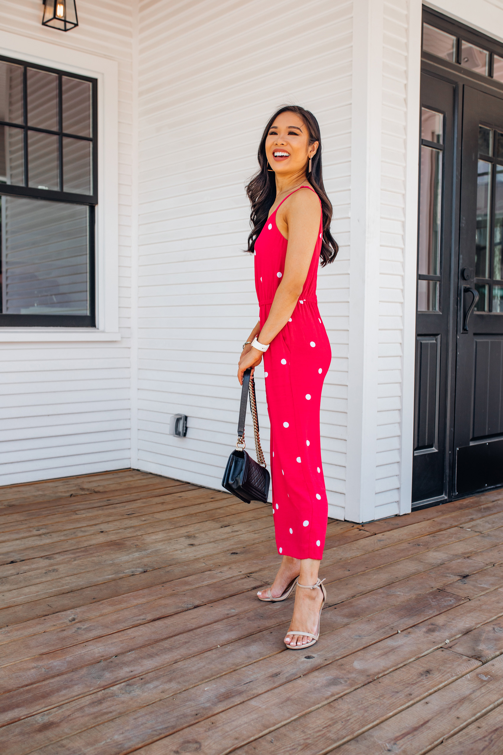 Petite blogger wearing a red polka dot jumpsuit with pockets and Kendra Scott earrings in Bishop Arts Dallas