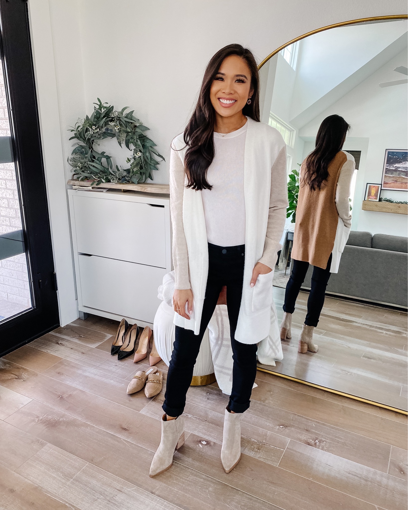 Blogger Hoang-Kim wears the Madewell Kent Colorblock Cardigan in Heathered TImber with Black AG The legging jeans, Marc Fisher Booties in her entryway with a Rejuvenation arched floor mirror