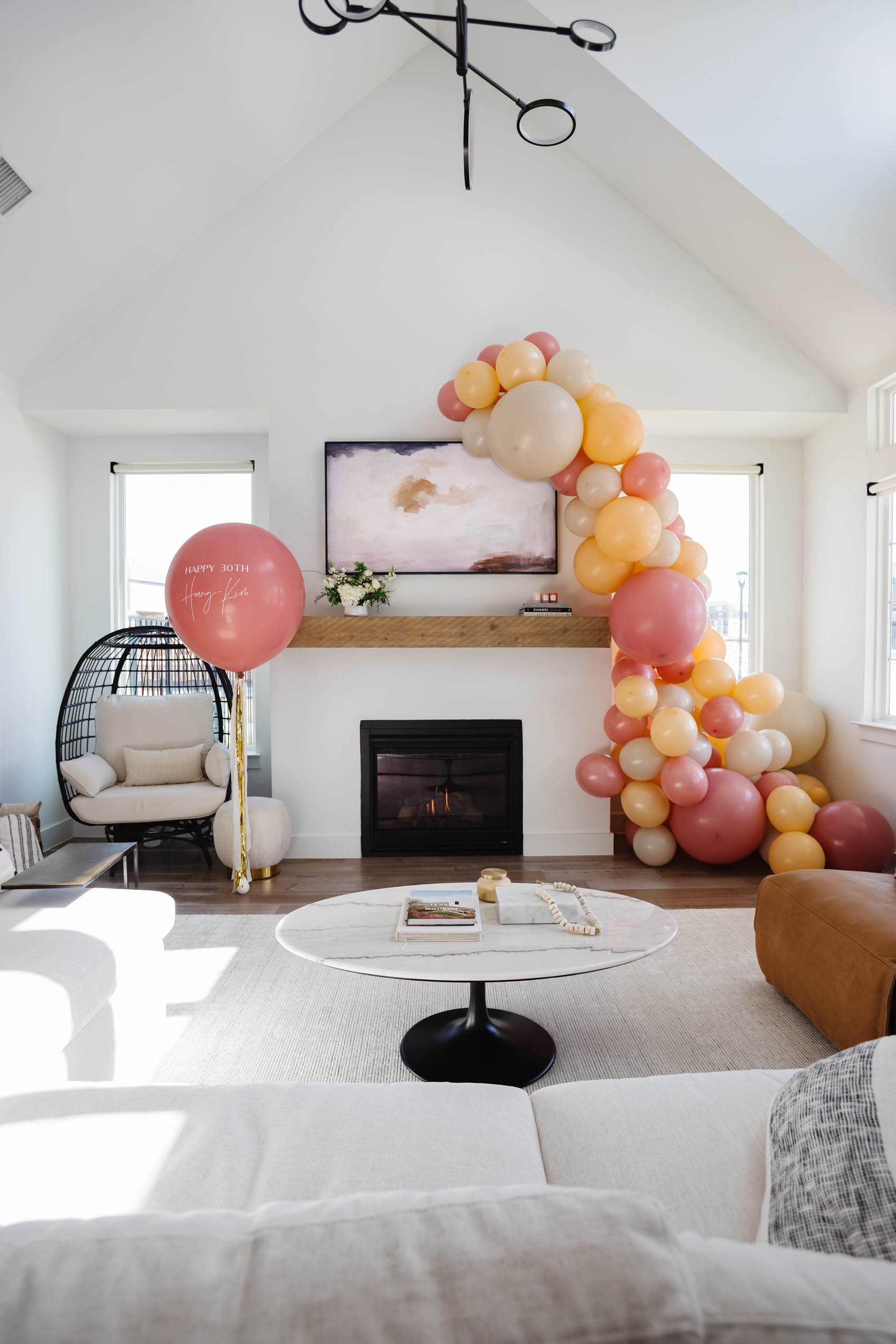 Balloon garland installation and custom jumbo balloon set up by Lushra in a Dallas Transitional Home for a 30th Birthday Party