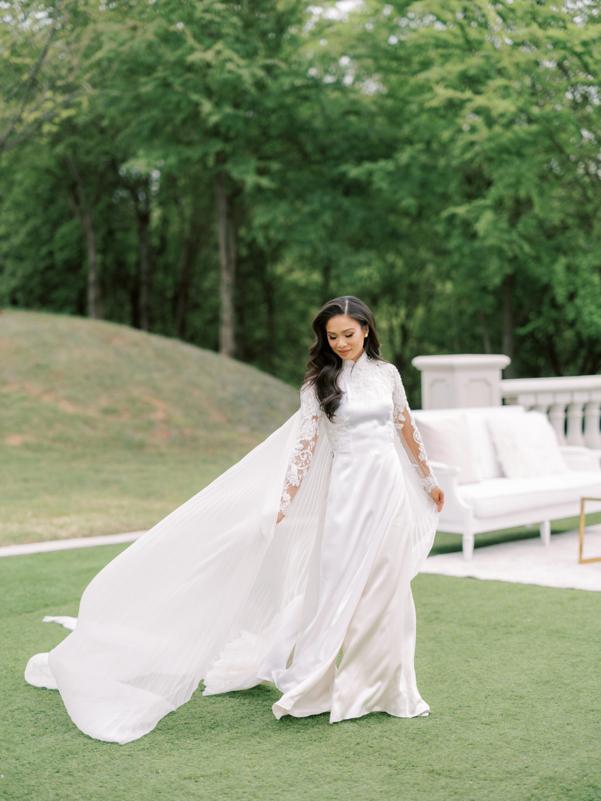 Hoang-Kim Cung wears a white wedding ao dai by Thai Nguyen atelier with a long pleated cape, French lace and pearl earrings by Olive + Piper