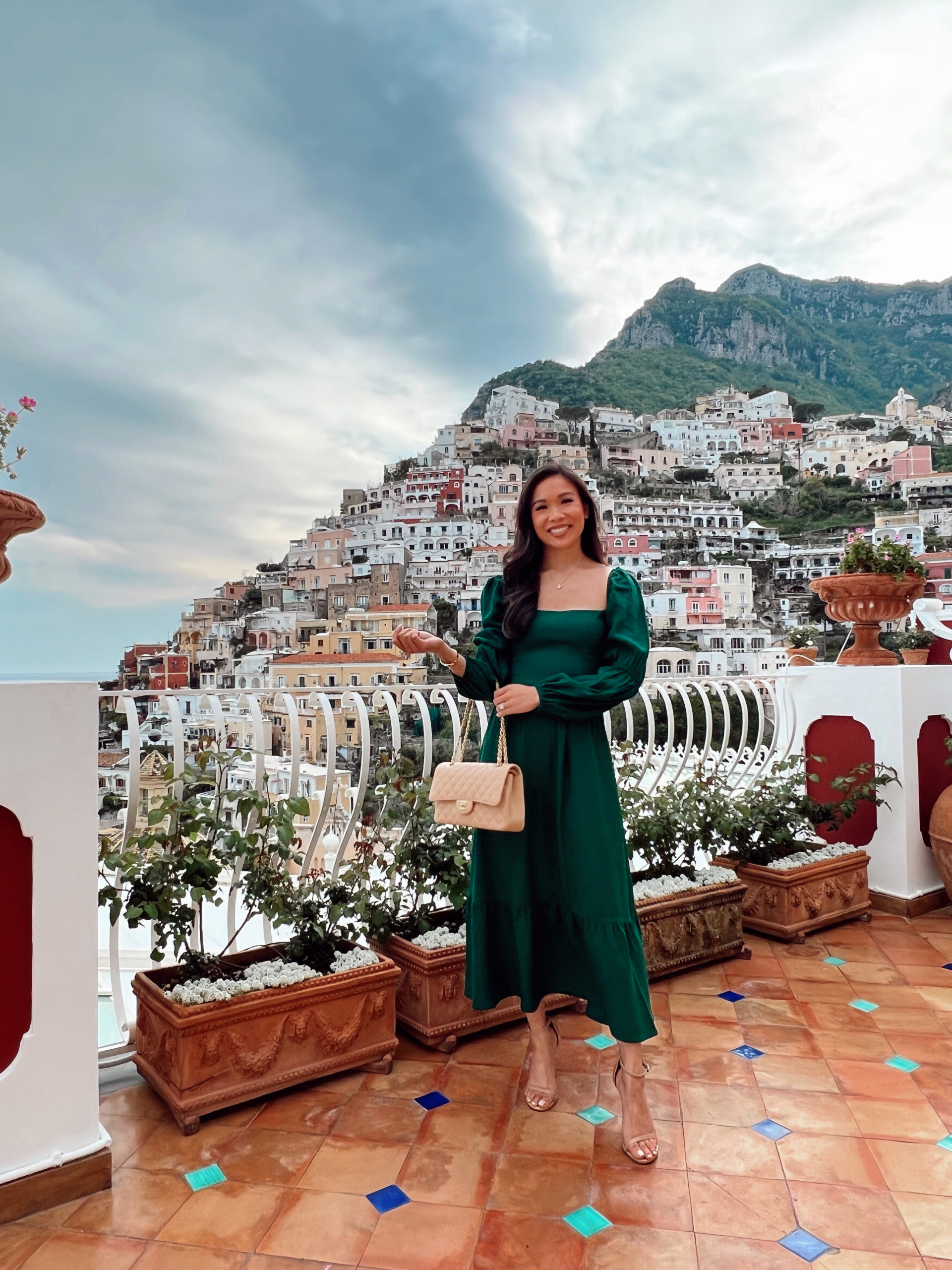 Hoang-Kim wears a green long sleeve Reformation dress at Le Sirenuse Hotel in Positano on the Amalfi Coast